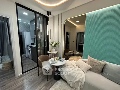 Modern living room with stylish decor and open kitchen layout, featuring cozy seating and elegant lighting.