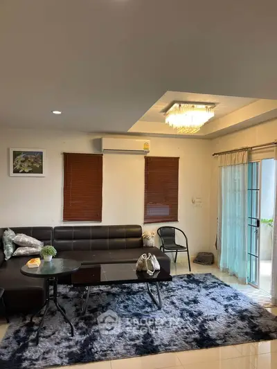 Stylish living room with modern decor, plush rug, and elegant lighting, perfect for relaxation and entertaining.