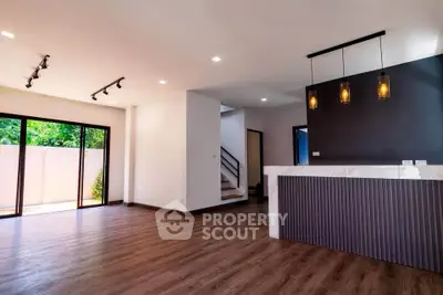 Spacious modern living room with elegant lighting and large windows for natural light.
