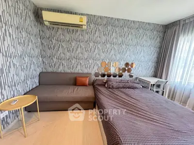 Modern bedroom with stylish wallpaper and cozy furnishings in a well-lit space.