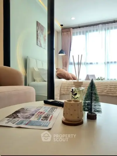 Cozy bedroom with modern decor and natural light, featuring a stylish coffee table and comfortable seating.