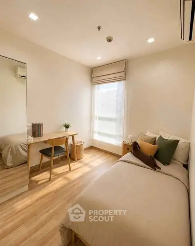 Cozy bedroom with wooden flooring, single bed, and study desk, perfect for a minimalist lifestyle.