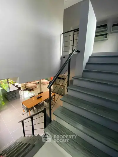 Modern open-plan interior with stylish staircase and spacious living area