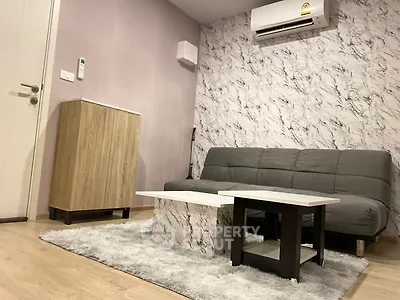 Modern living room with stylish marble accent wall and cozy gray sofa