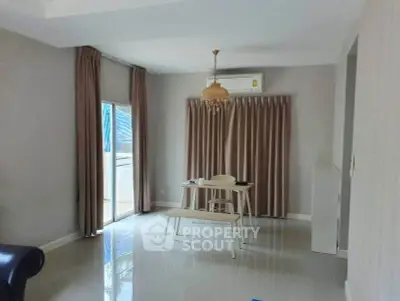 Modern living room with sleek design, featuring large windows and elegant curtains.