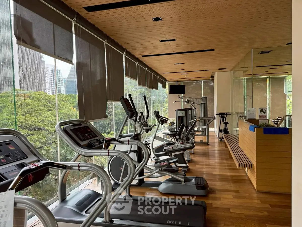 Luxurious gym with modern equipment and stunning city views, perfect for fitness enthusiasts.