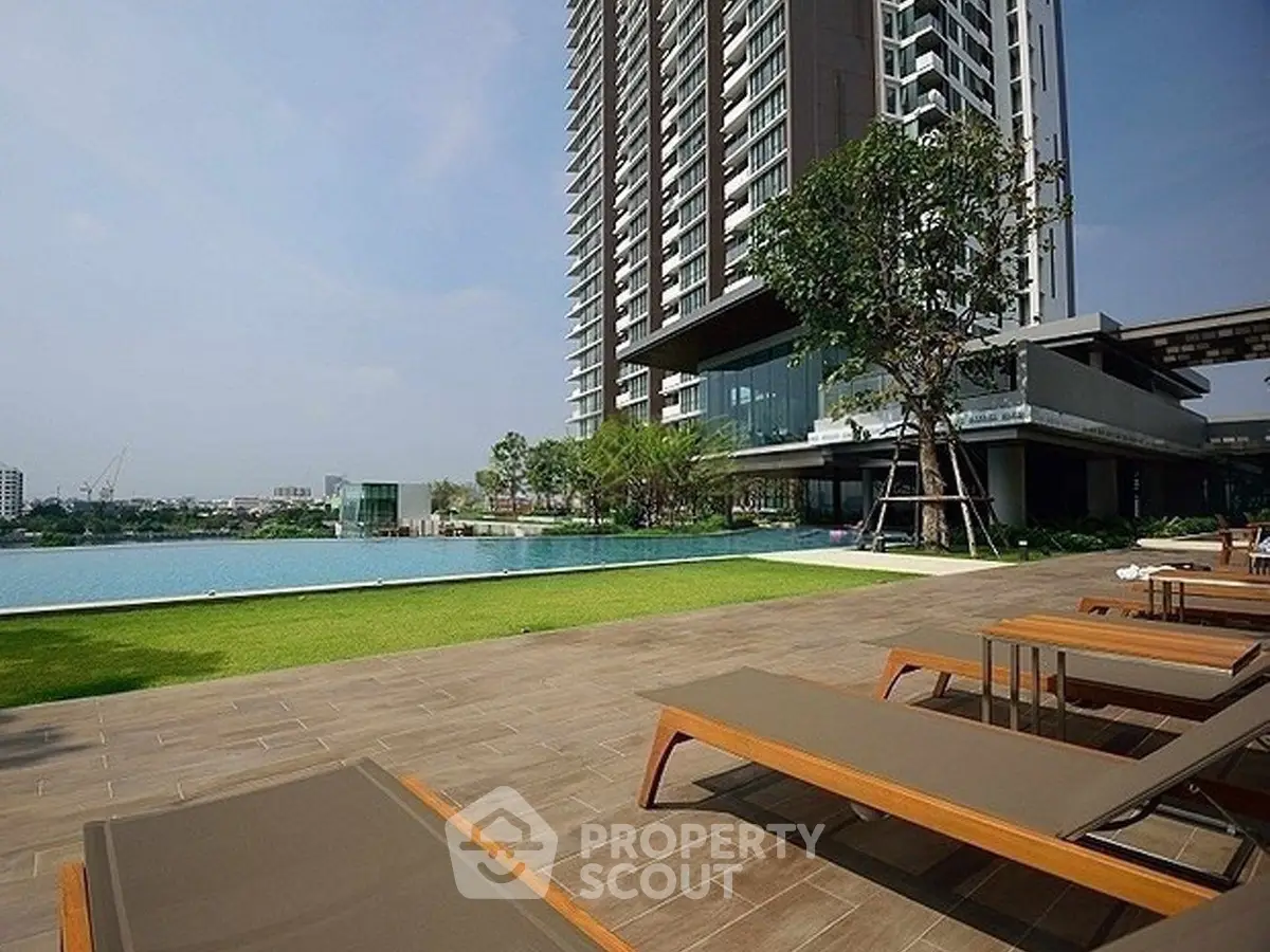 Luxurious high-rise building with poolside relaxation area and stunning city views.