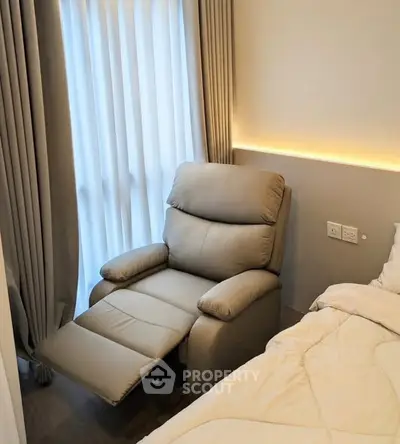 Cozy bedroom corner with plush recliner and soft lighting