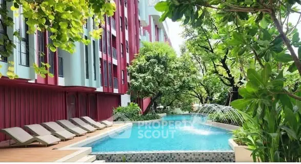 Luxurious apartment complex with serene pool and lush greenery, perfect for relaxation and leisure.