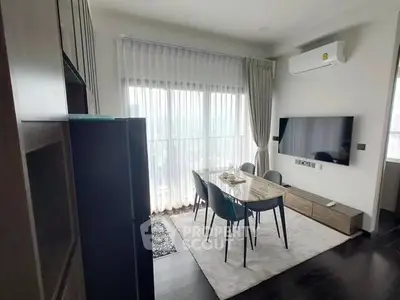 Modern living room with sleek furniture and large windows offering natural light.