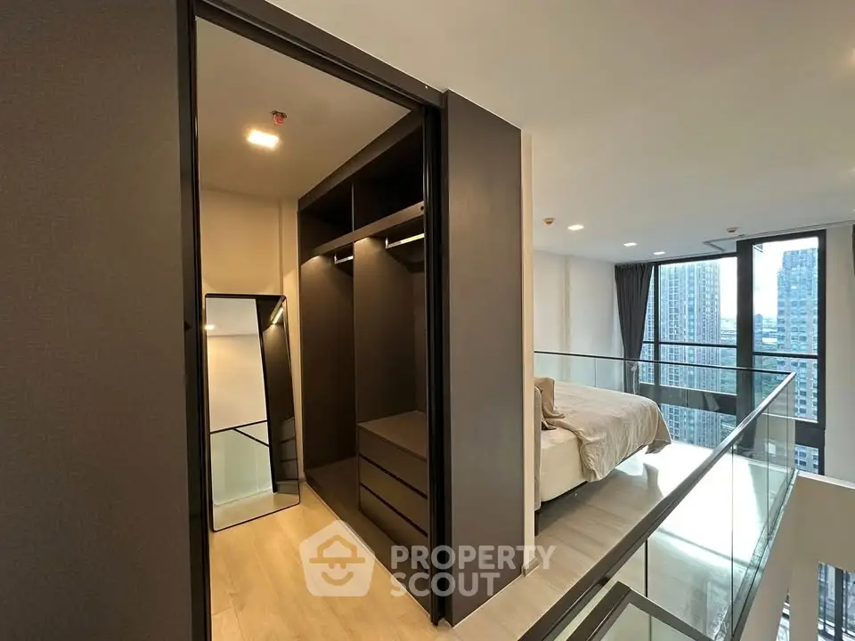 Modern loft bedroom with walk-in closet and city view, featuring sleek design and ample natural light.