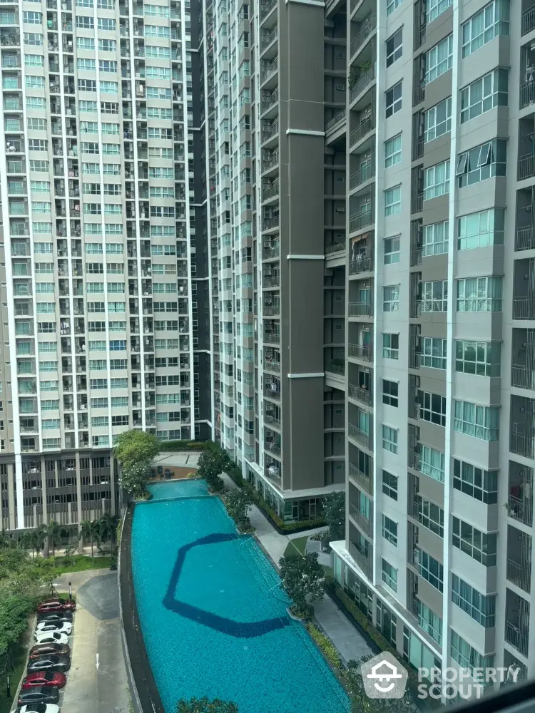 High-rise residential complex with swimming pool and parking area view