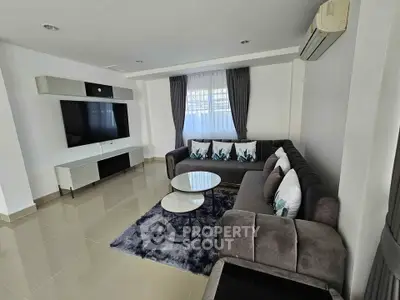 Modern living room with sleek furniture and large TV, perfect for relaxation.