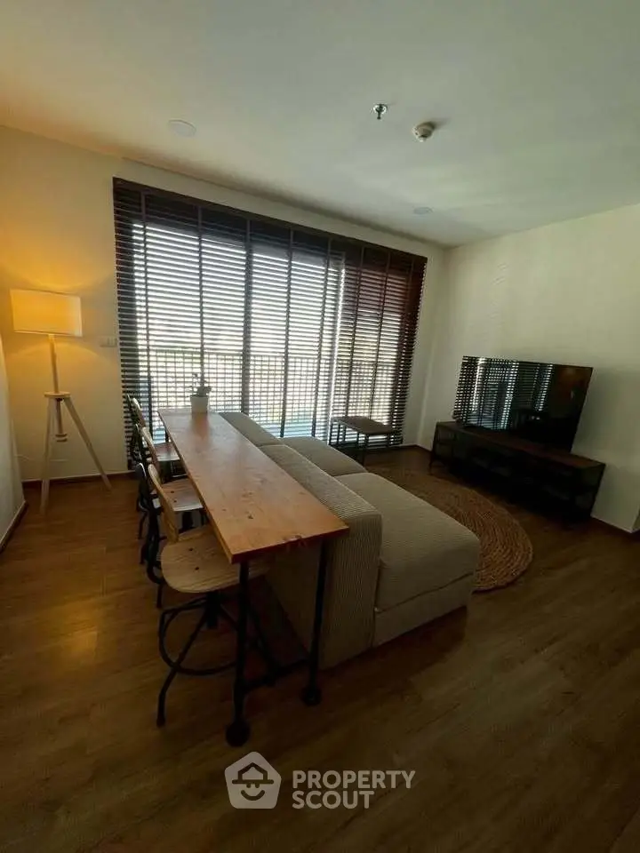 Stylish living room with cozy sofa, wooden floor, and large window for natural light.