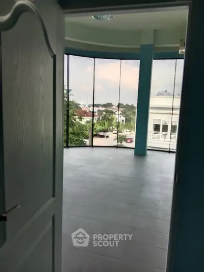 Spacious room with large windows offering a panoramic view of the neighborhood.
