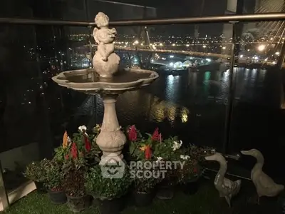 Stunning balcony view with elegant fountain and city lights, perfect for relaxation and entertaining.