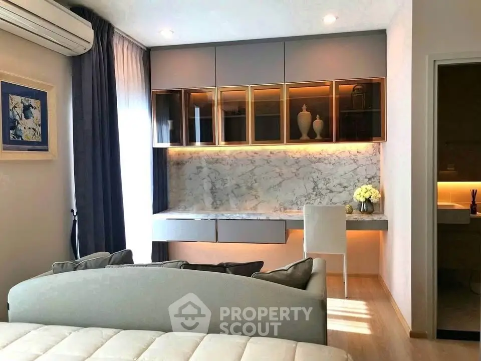 Modern living room with elegant decor and built-in storage, featuring a cozy seating area and stylish lighting.