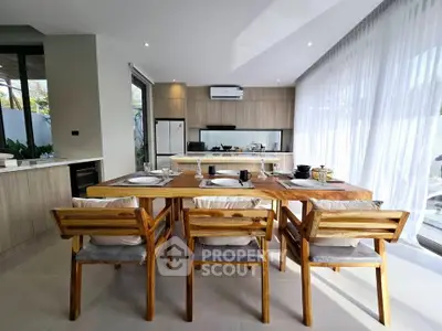 Modern kitchen with open layout and stylish dining area featuring wooden furniture and natural light.