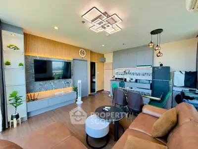 Modern living room with open kitchen, stylish lighting, and sleek furniture design.