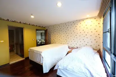 Spacious bedroom with twin beds and stylish wallpaper, perfect for a cozy retreat.