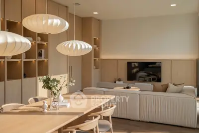 Modern living room with elegant lighting and cozy seating area, featuring a stylish wooden dining table.