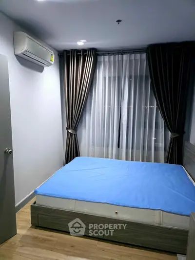 Modern bedroom with air conditioning and stylish curtains in a cozy apartment.