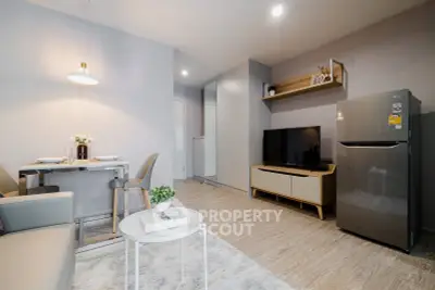 Modern living room with dining area and sleek kitchen appliances in a stylish apartment.