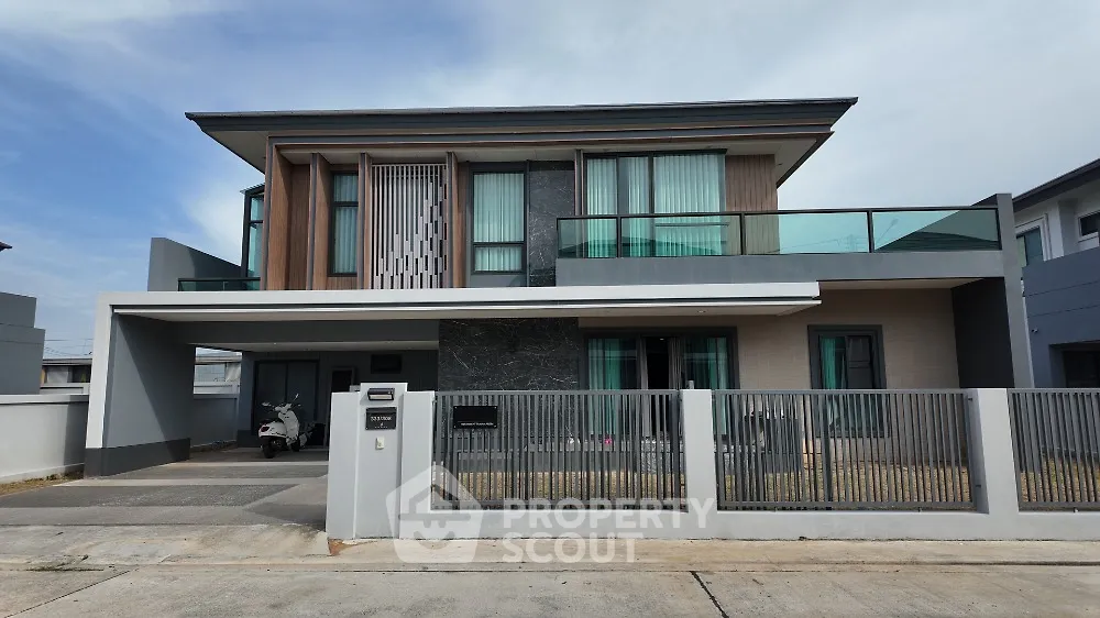 Modern two-story house with sleek design and spacious balcony in suburban neighborhood.