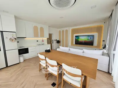 Modern open-layout kitchen and living room with stylish decor and wooden dining table.