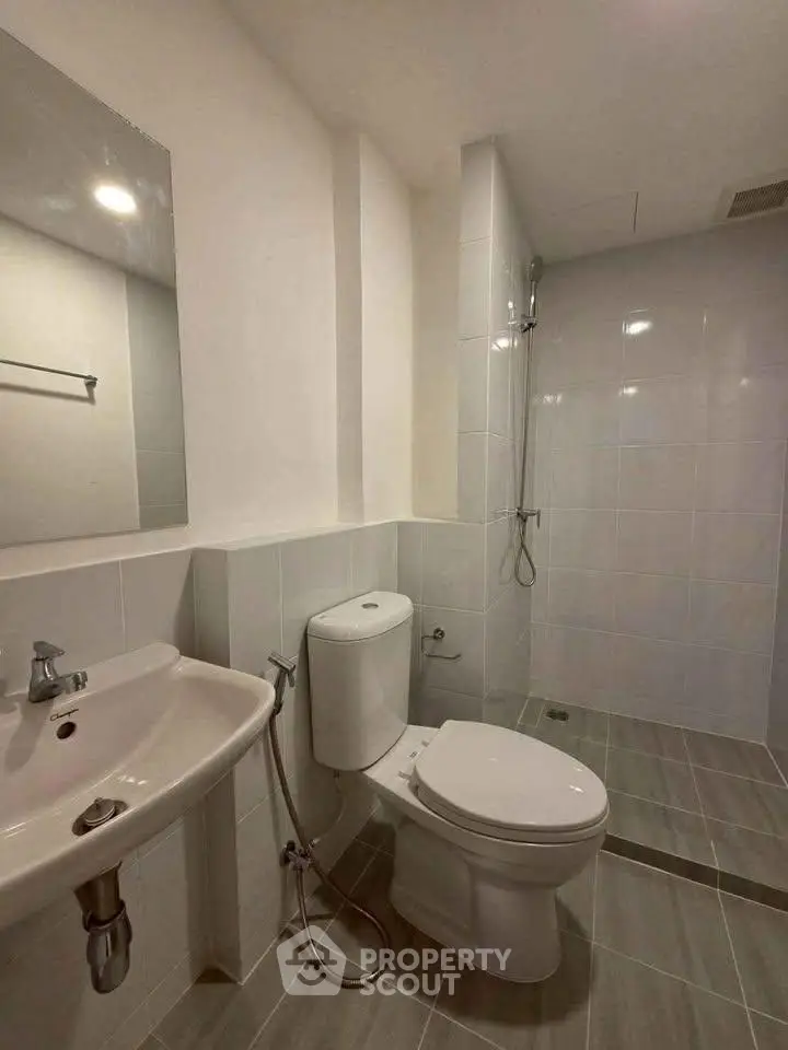 Modern bathroom with sleek fixtures and walk-in shower in a contemporary apartment.