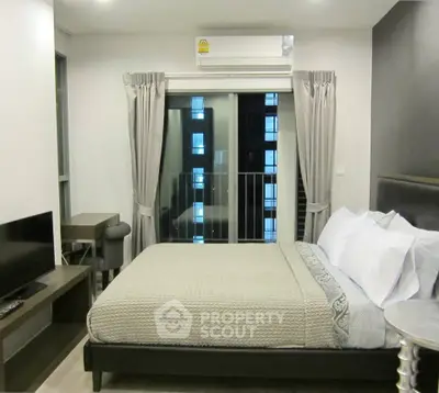 Modern bedroom with balcony view in a stylish apartment, featuring a cozy bed and sleek furnishings.