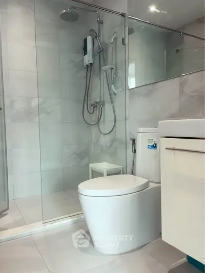 Modern bathroom with glass shower and sleek fixtures in a contemporary apartment.