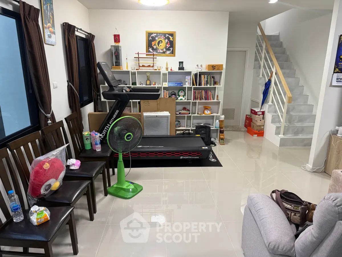 Modern living room with treadmill and stylish shelving, perfect for fitness enthusiasts and cozy living.