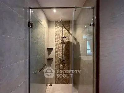 Modern bathroom with glass shower enclosure and stylish tile design.
