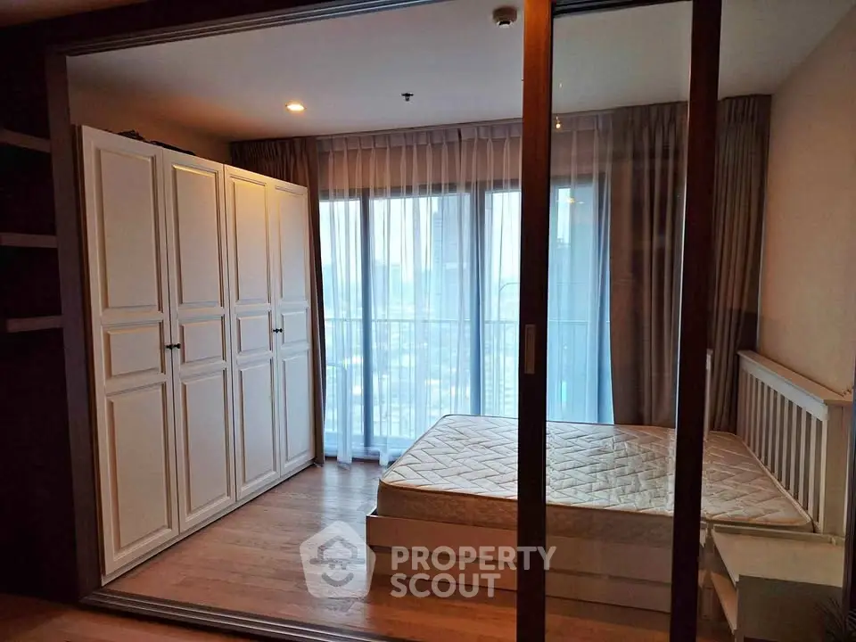 Spacious bedroom with large wardrobe and city view in modern apartment