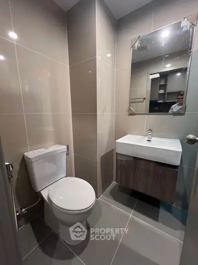 Modern bathroom with sleek fixtures and neutral tiles in a contemporary apartment.