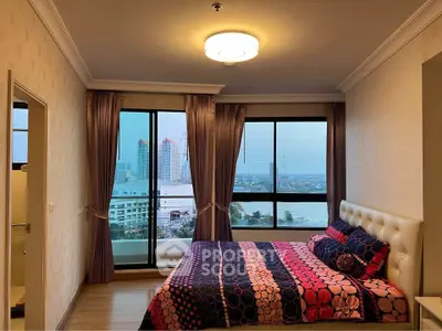 Spacious bedroom with stunning city view and elegant decor in modern apartment.