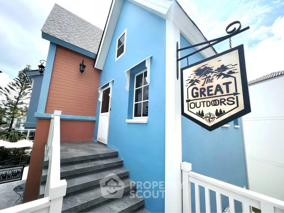 Charming blue and orange building with rustic outdoor sign, ideal for unique real estate opportunities.