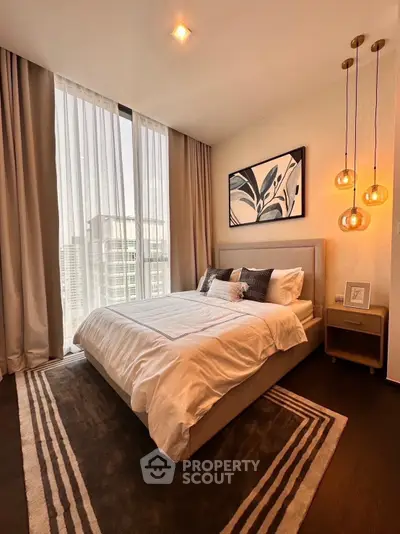 Luxurious bedroom with modern decor and large window offering city views, perfect for urban living.