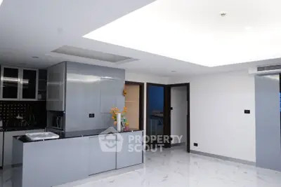 Modern kitchen with sleek cabinets and marble flooring in a contemporary apartment.