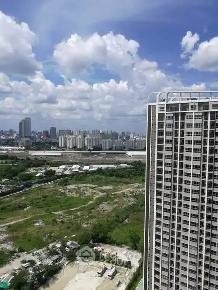 Stunning cityscape view from high-rise building with lush greenery and urban skyline.