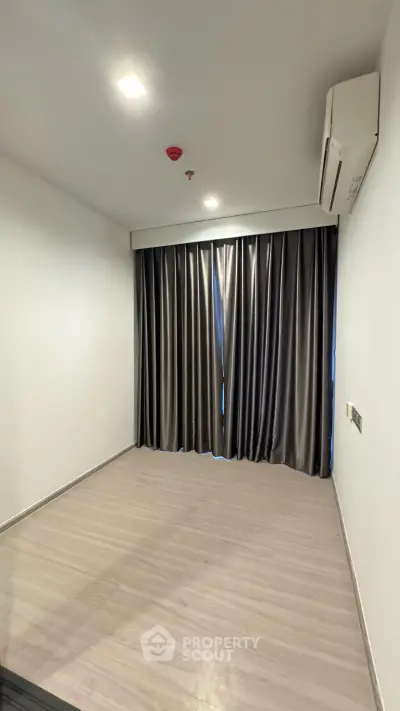 Spacious empty room with modern flooring and elegant curtains, perfect for customization.