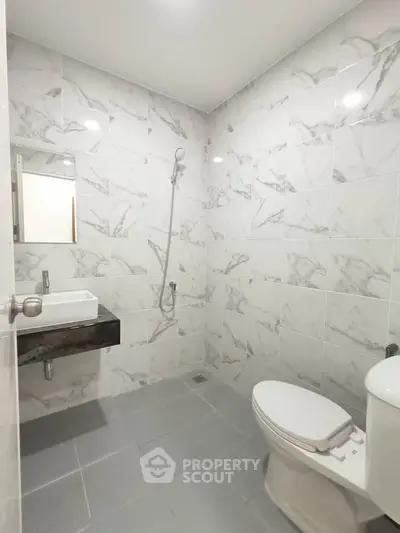 Modern bathroom with marble tiles and sleek fixtures in a contemporary home.