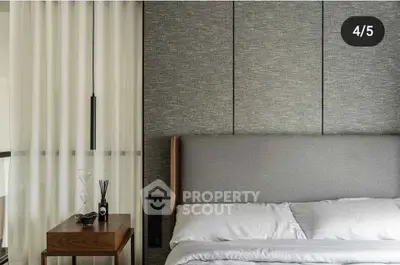 Modern bedroom with elegant decor and cozy bedding in a stylish apartment.