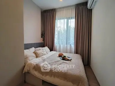 Cozy bedroom with large window and soft lighting, perfect for relaxation.