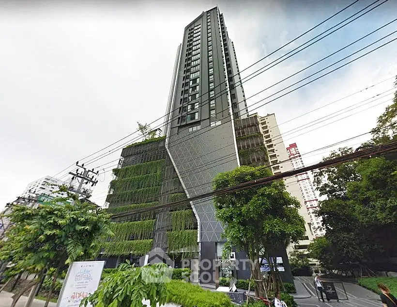 Modern high-rise building with lush greenery and unique architectural design