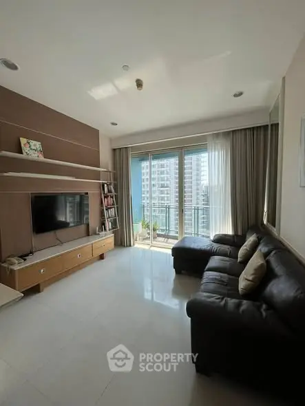 Spacious living room with modern decor and large windows offering city views.