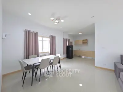 Spacious modern living room with dining area and open kitchen in a bright apartment.