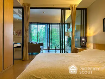 Luxurious bedroom with sliding glass doors opening to a spacious living area and lush garden view.