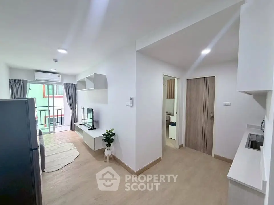 Modern open-plan living room with balcony access in a bright apartment